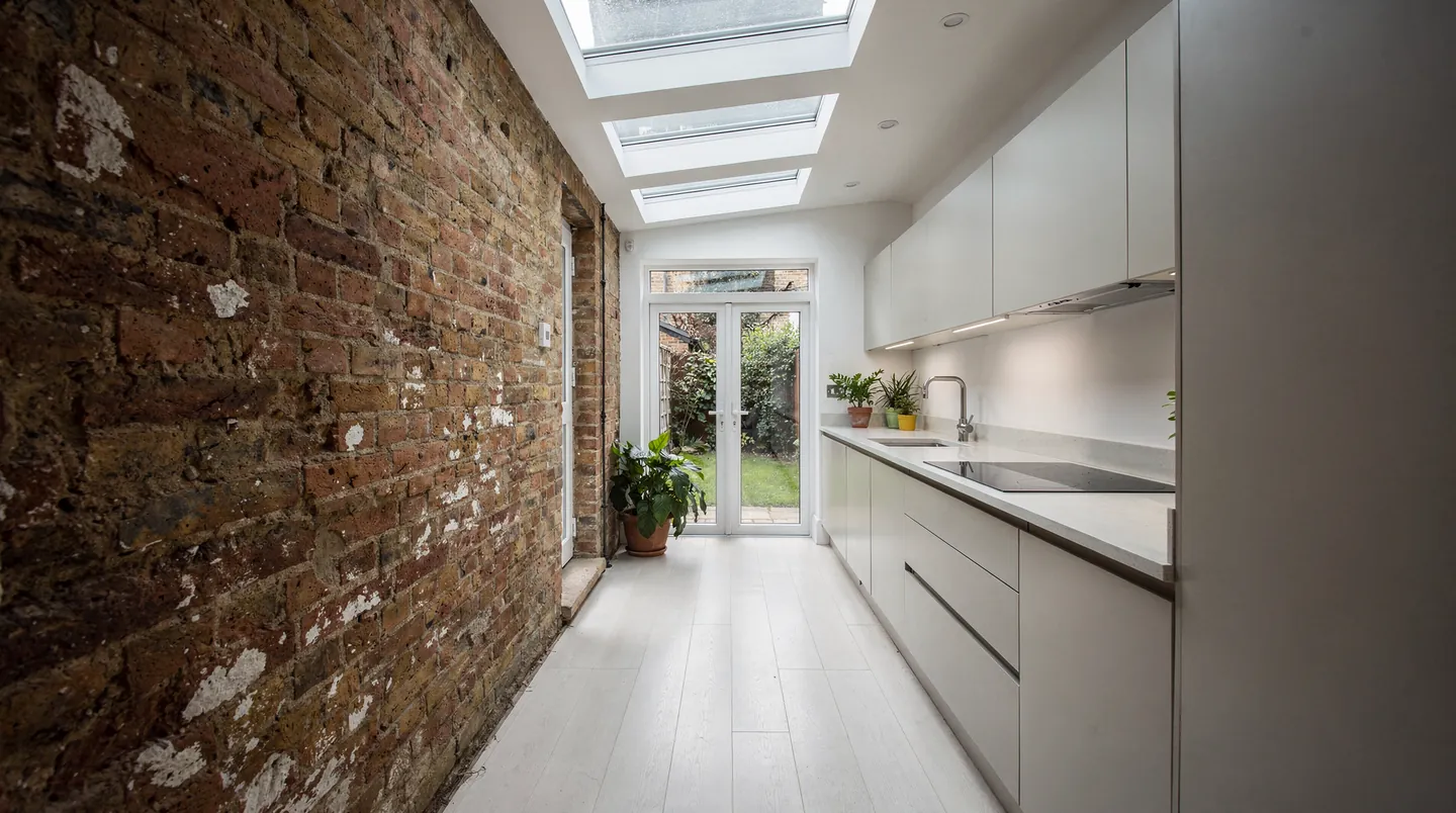 Three flat rooflights in a row above a narrow side-return kitchen on a terraced house