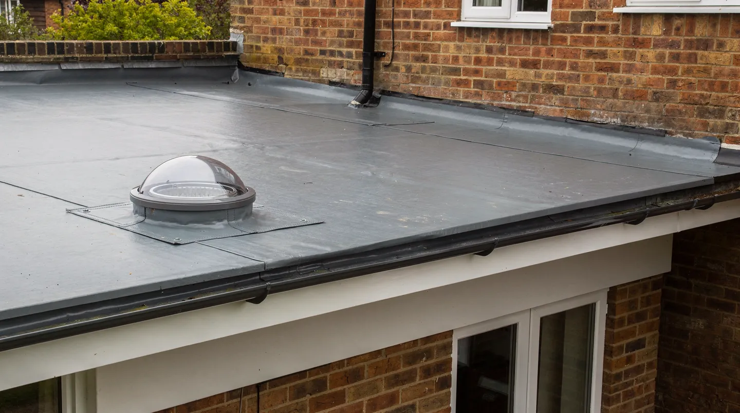 A round clear dome on a grey flat roof extension